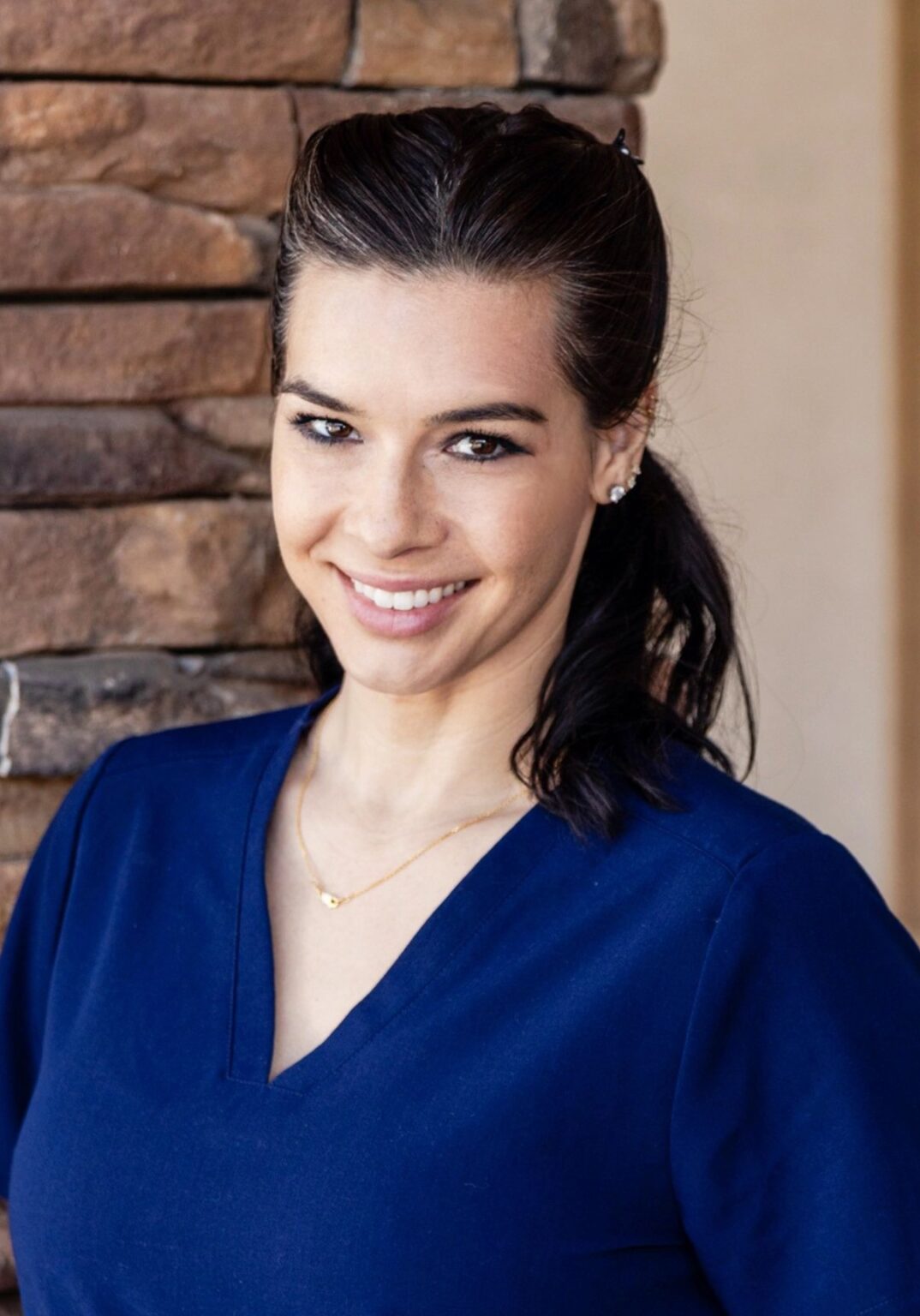 A woman in blue shirt smiling for the camera.